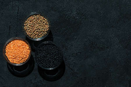 Red, black, brown seeds of dry lentils on dark backgroundの写真素材