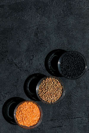 Red, black, brown seeds of dry lentils on dark backgroundの写真素材