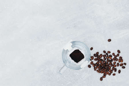 Clean glass mug with a drip coffee bag, where the coffee is poured, next to coffee beans, view from above, a copy space, light backgroundの写真素材