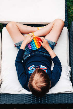 boy on couch in the street plays fidget toyの写真素材