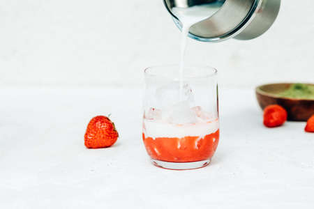 Cooking a summer refreshing milk drink with strawberries and matchaの写真素材