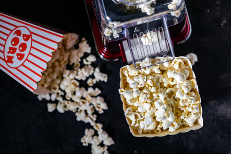 Making popcorn at home, a full bucket of ready-made popcorn on a dark backgroundの写真素材