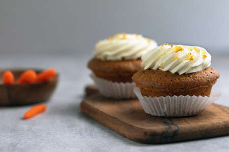 carrot cupcake on a wooden board, ingredients on the backの写真素材