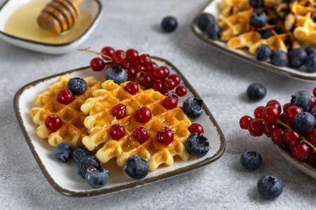 breakfast served - waffles with berries and honeyの写真素材