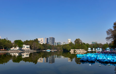Mexico DF,02-06-2025: Boats on Chapultepec Forest Lake with the Mexico City Skyline in the...