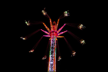 Flying swings lit up during fair nightの写真素材