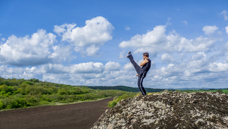 Young man training martial arts in natureの写真素材