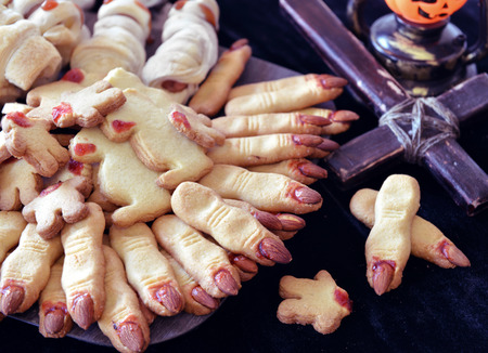 Halloween still life with close up of finger cookies and wooden cross. Magic ritual with mystic objectsの写真素材