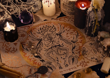 Close up of demon drawing on old parchment and magic ritual objects.  Halloween concept. Occult objects on table. There is no foreign text in the image, all symbols are imaginary and fantasy onesの写真素材