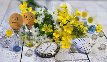 Vintage pocket clocks, tiny bottles with tags drink me, eat me, and crystal balls on planks. Alice...