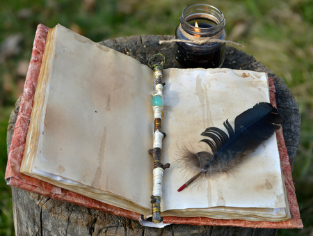 Old book with empty pages, magic wand, quill and black candle. Occult, esoteric, divination and wicca concept, mystic backgroundの写真素材