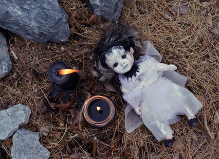Scary still life with voodoo girl and black candles. Mystic background with ritual esoteric objects, occult and halloween conceptの写真素材