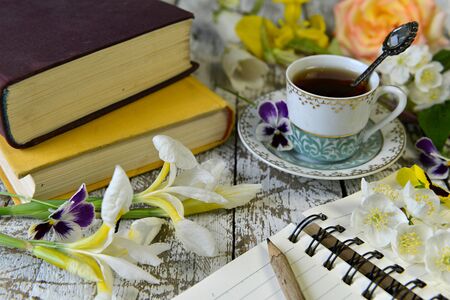 Pile of old books, diary and cup of tea on table. Vintage still life, poetry and literature reading conceptの写真素材