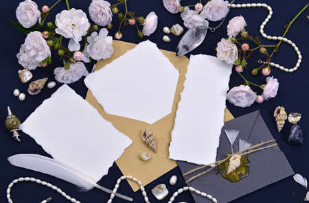 Decorated envelopes with empty paper sheets, quill, decorations and roses. Mystic and romantic background with copy space and blank, vintage romantic concept for mock up, top viewの写真素材