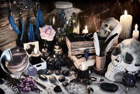 Mysterious still life with runes, evil skull and spell book on witch table.  Esoteric, gothic and...