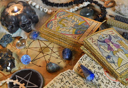 Fortune telling ritual with tarot cards, pentagram, black candle and crystals on witch table. Esoteric, gothic and occult background, Halloween mystic concept.の写真素材