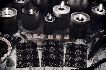 Still life with tarot cards, runes and black candles on witch table. Esoteric, gothic and occult background, Halloween mystic concept.の写真素材