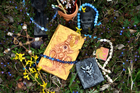 Magic book of spells with candles and crystals on altar in the garden. Occult, esoteric and...