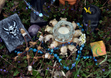 Magic books with candles, crystals and pentagram on witch altar in the garden. Occult, esoteric and...