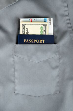 american passport with money and boarding pass in a front pocket of a shirtの写真素材