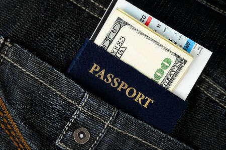 passport with boarding pass and money in black jeansの写真素材