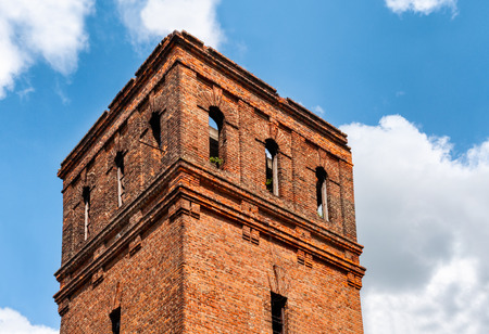 Abandoned brick tower with blue skies and cloudsの写真素材