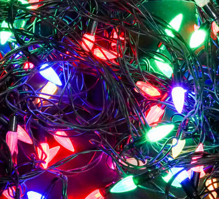 Glowing colorful Christmas lights on black backgroundの写真素材