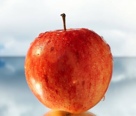 Apple with reflexion against the skyの写真素材