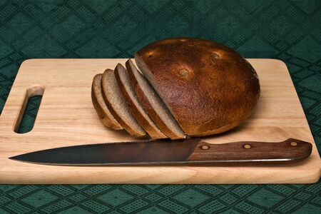 Brown bread and knife on a chopping board