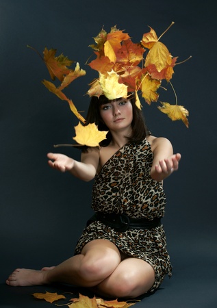 The girl with falling maple leavesの写真素材