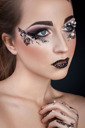 Girl with  creative Makeup with Pearls and Shards on black backgroundの写真素材