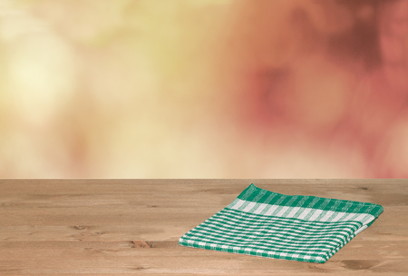 Empty wooden deck table with tablecloth for product montage. Free space for your text