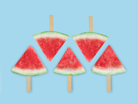 Slices of watermelon on a light blue background. Chopped watermelon. Summer concept. Flat lay, top...