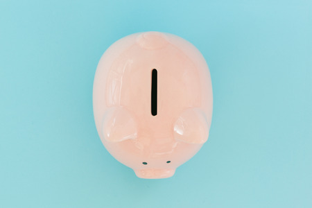 Piggy bank money on blue background. Savings conceptの写真素材