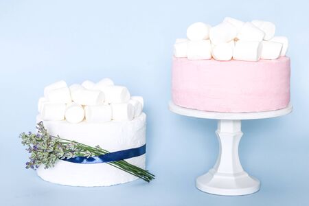 Pink wedding or birthday cake with lavender flowers on blue backgroundの写真素材