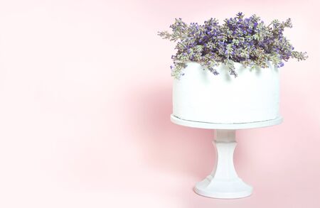 White wedding cake with lavender flowers on pink backgroundの写真素材