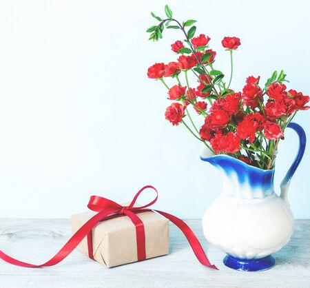 Present or gift box in a craft paper with red ribbon bow on white background. Greeting card for Valentine's or Mother Day.の写真素材