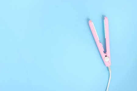 Hair straightener on blue background. Top view, flat lay. Minimalismの写真素材