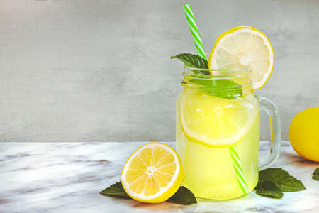 Lemon lemonade in mason jar glass made fruit on table background. Cold summer beredge. Mojito...