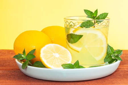 Lemonade or mojito cocktail with lemon and mint, cold refreshing drink or beverage with iceの写真素材