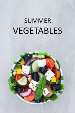 Healthy vegetable greek salad of fresh tomato, cucumber, cheese feta, on plate. Diet menu. Top view.の写真素材