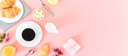 Morning breakfast coffee and croissant, butter, orange juice and flowers on white background. Flat lay, top viewの写真素材