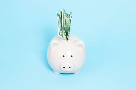 Piggy bank money on blue background. Savings concept.
