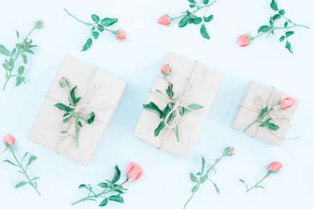 Gift or present box wrapped in craft paper and rose flower on blue table top view. Flat lay styling. Copy space for text.の写真素材