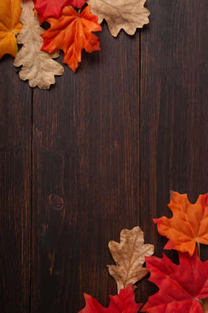 Autumn maple leaves oak on brown wooden table. Fall background with empty space for text. Top view