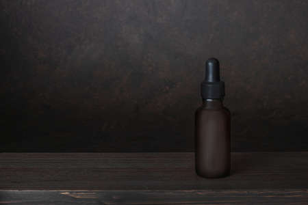 Bottle of oil, essential on wooden table and dark borwn background. Concept of aroma oil,...
