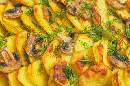 Potato wedges baked with mushrooms, herb oven roasted, with thyme, a close-up in a baking tray. Top viewの写真素材