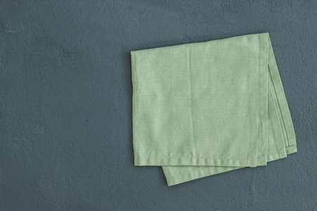 Green napkin isolated on black background. Decorative kitcchen cotton towel.の写真素材