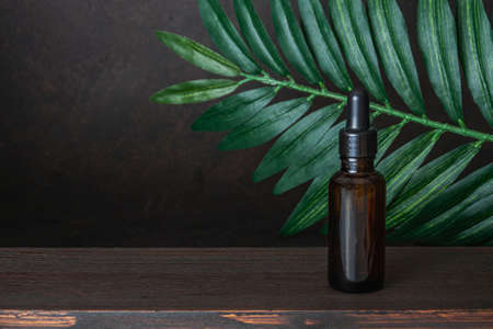 Bottle of oil, essential on wooden table and dark borwn background. Concept of aroma oil,...