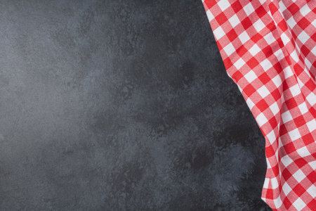 Tablecloth and napkin on black table. Empty kitchen dark background with copy space in rustic design for restaurant, menu and recipe. food backdropの写真素材